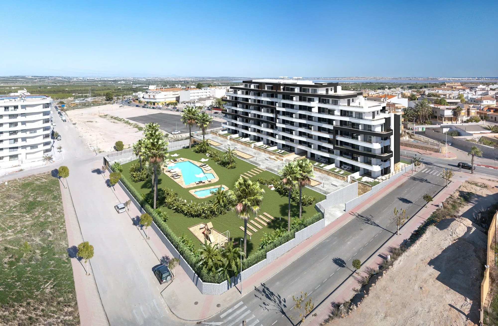 Aerial render of Duly San Miguel from the street corner, with the fenced garden, the two pools and the town behind