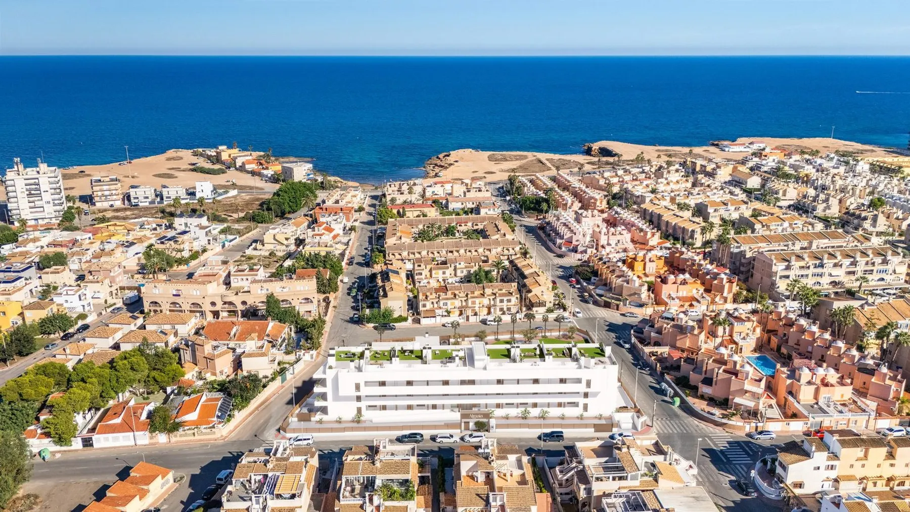 Aerial photo of Cabo Cervera with the Almaia building rendered in the foreground and the Mediterranean and the rocky shore beyond