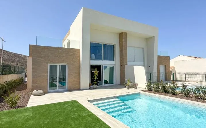 Photo of the built LEROS show home 1901: a two-storey white and stone façade, a pool with built-in steps and a lawn in front