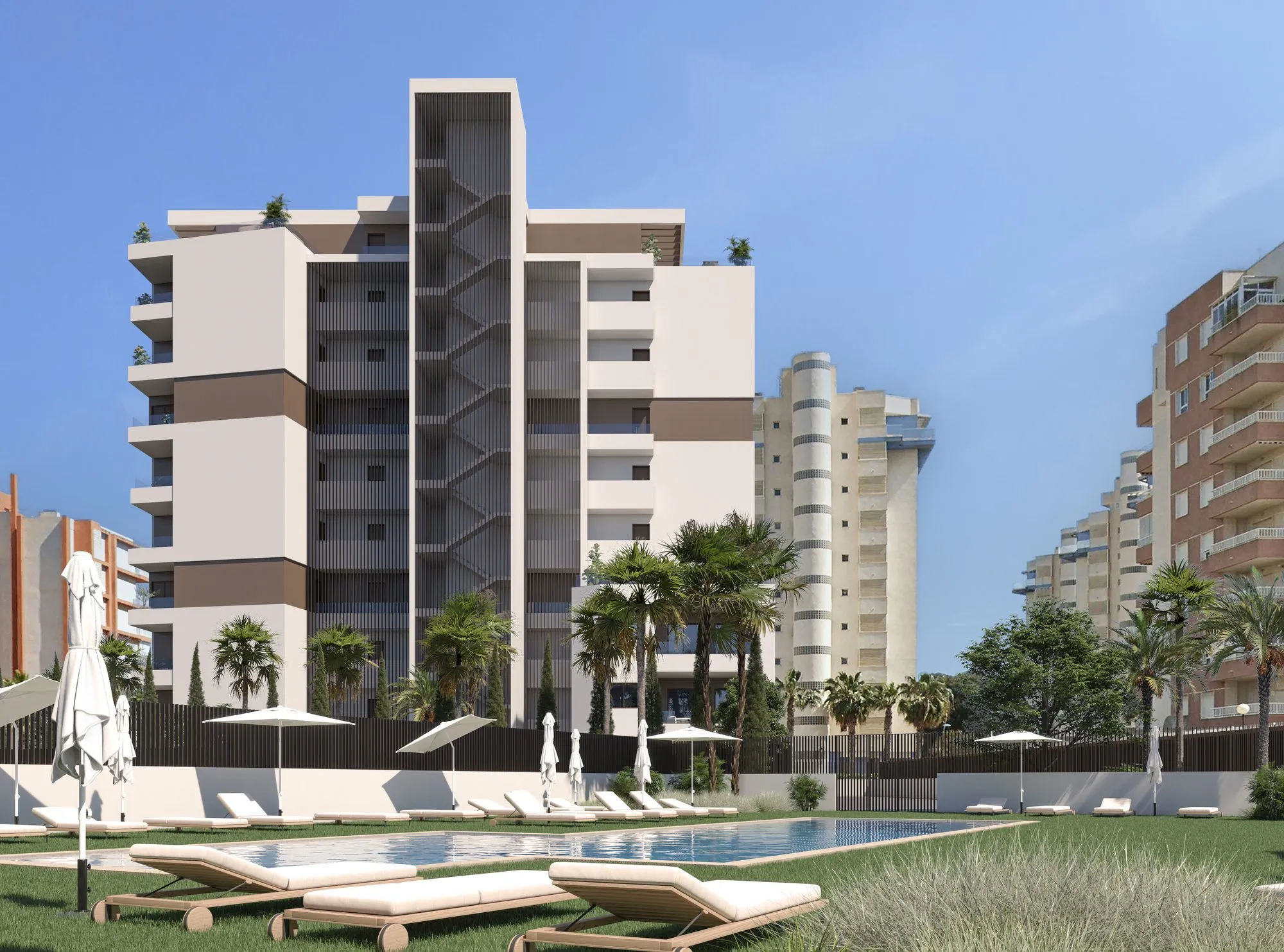 Render of the Guardamar Rio communal pool with sun loungers and lawn, and the ten-storey building behind